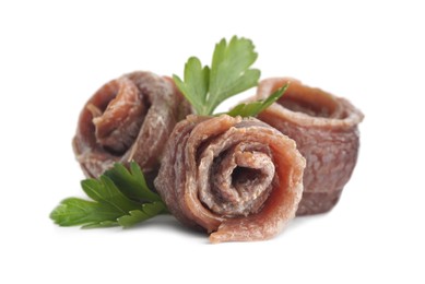Photo of Delicious rolled anchovy fillets and parsley on white background