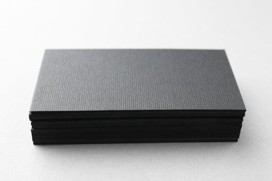 Photo of Blank black business cards on white table, closeup. Mockup for design