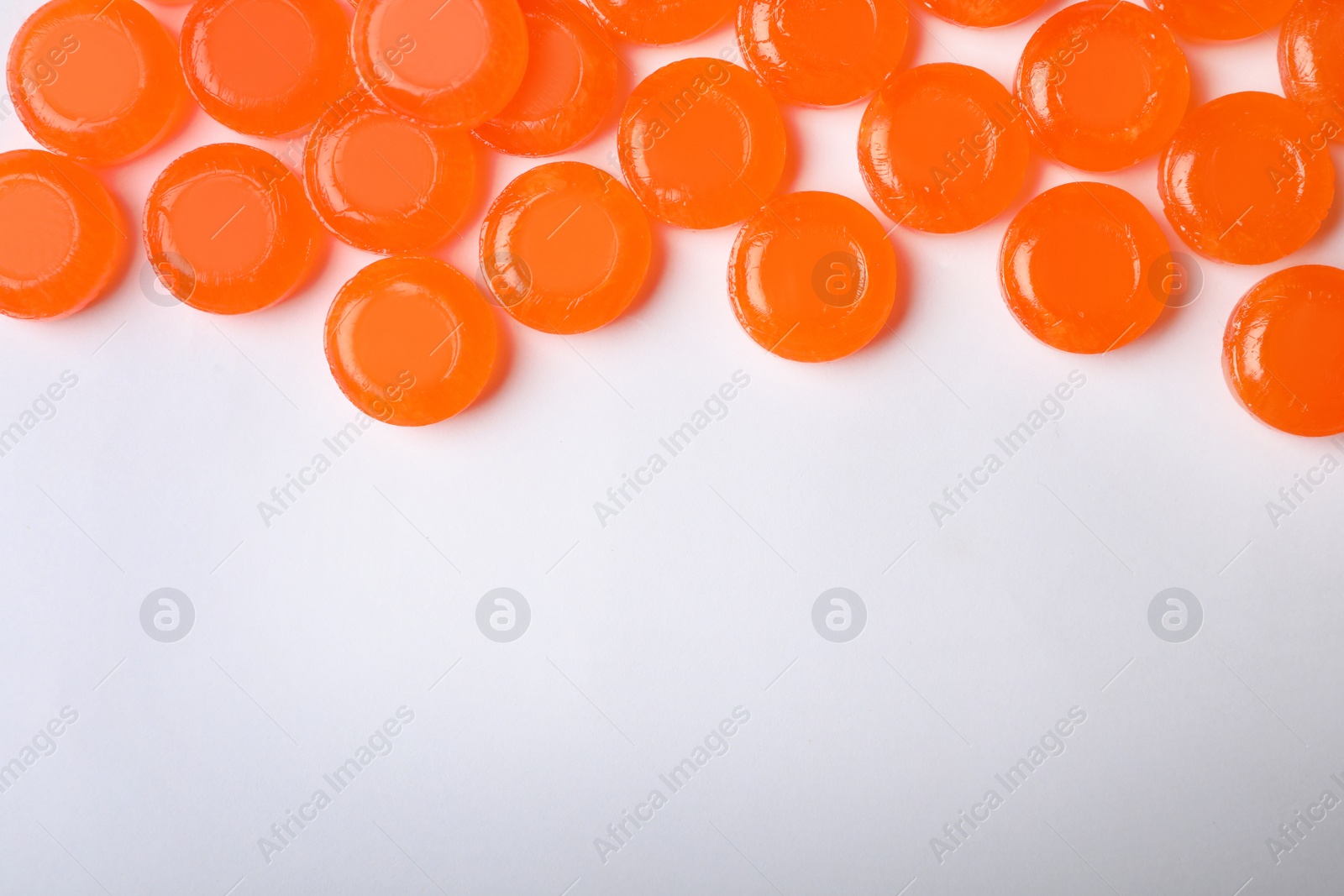 Photo of Color cough drops on white background. Top view with space for text