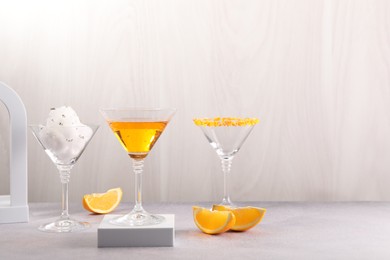 Cotton candy and cocktails in glasses on gray table, space for text