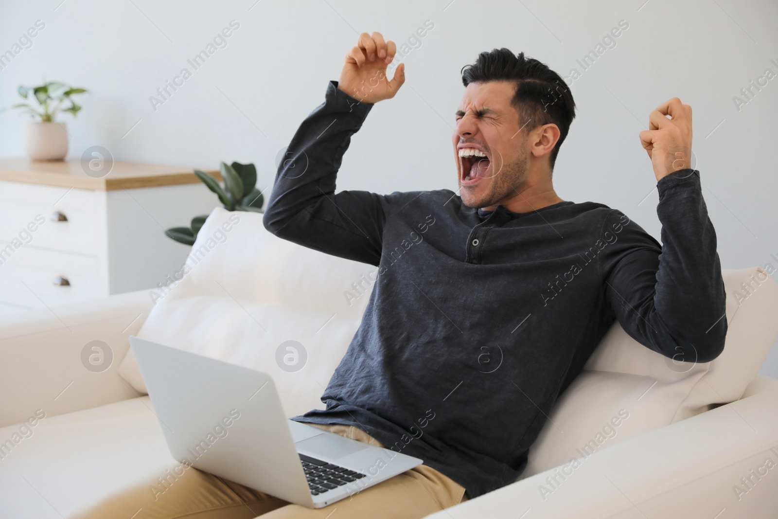 Photo of Emotional man working with laptop at home
