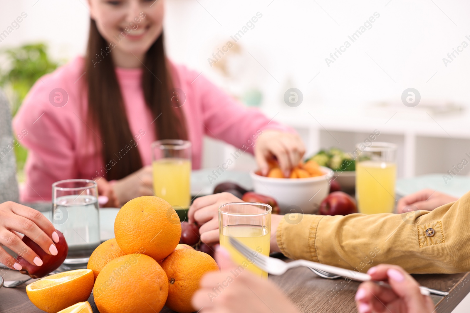 Photo of Friends eating vegetarian food at table indoors, closeup