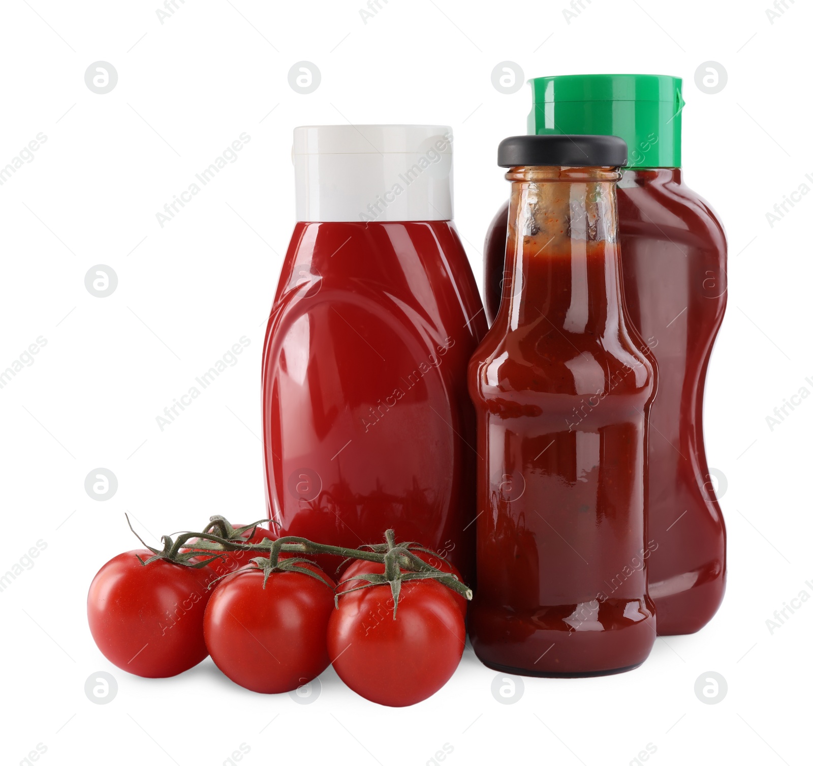 Photo of Different bottles of tasty ketchup and fresh tomatoes isolated on white