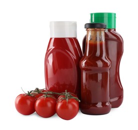 Different bottles of tasty ketchup and fresh tomatoes isolated on white