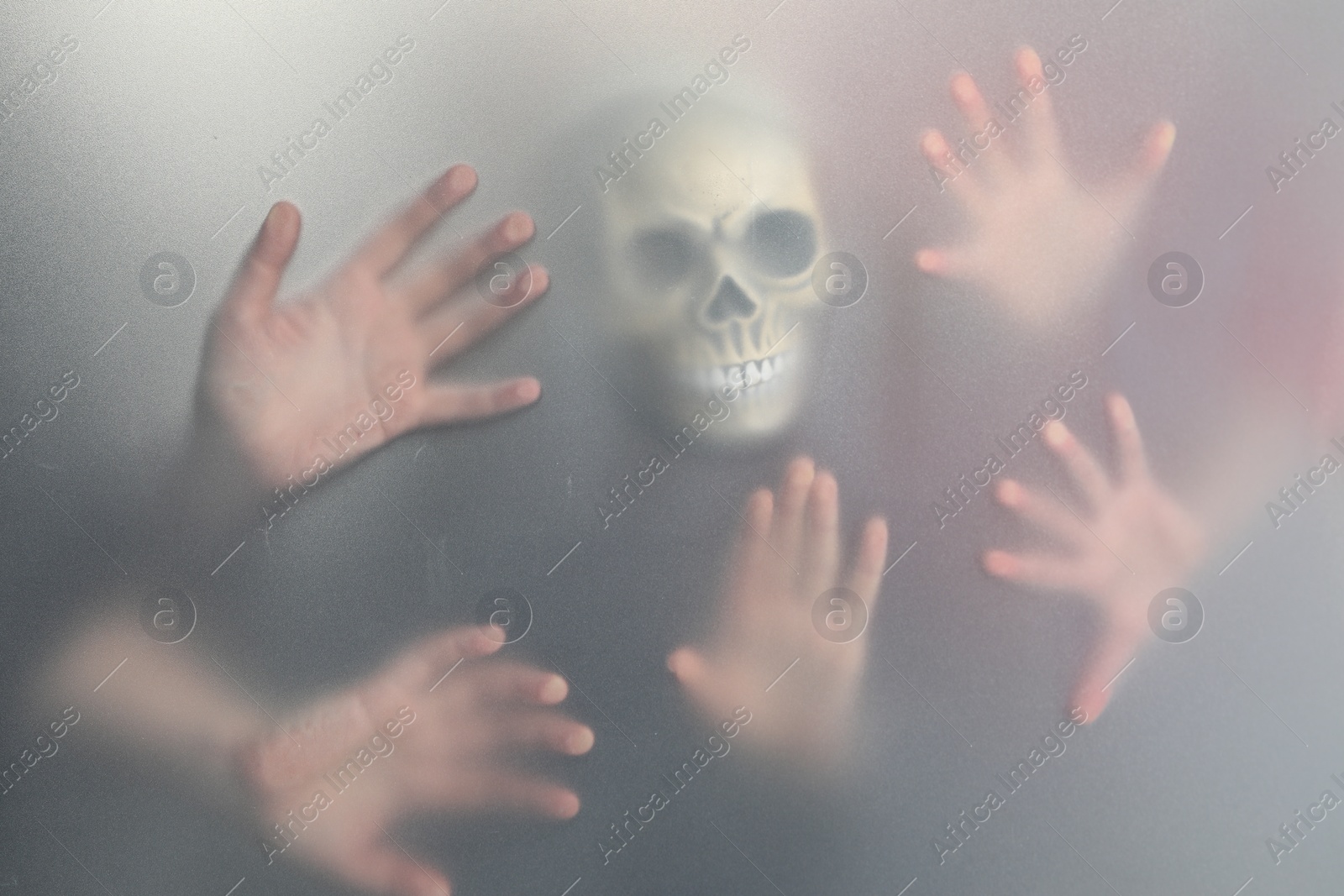 Photo of Silhouette of creepy ghost with skull behind cloth