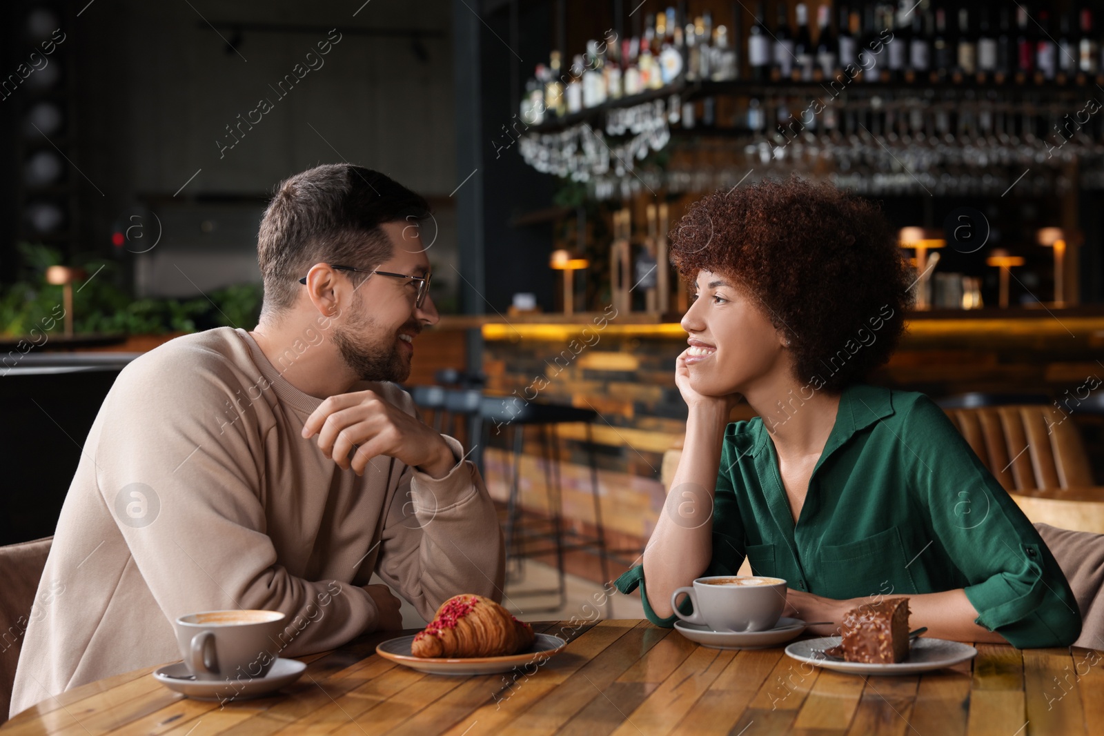 Photo of International relationships. Lovely couple having romantic date in cafe