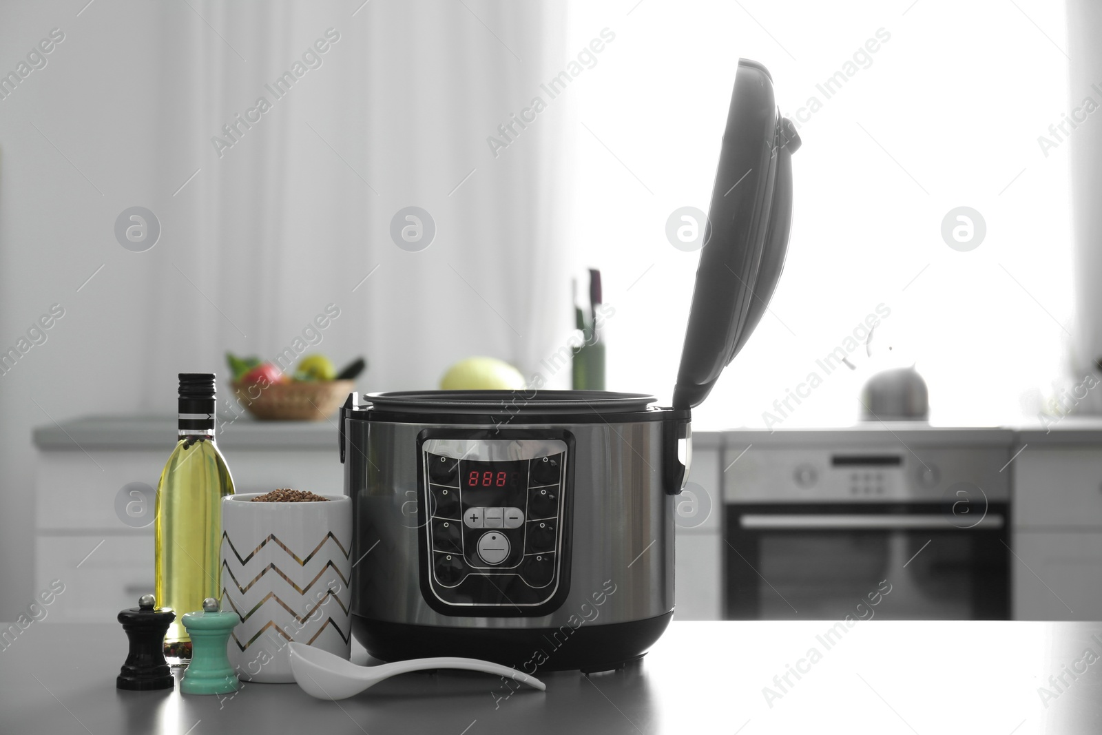 Photo of Modern multi cooker and products on table in kitchen. Space for text