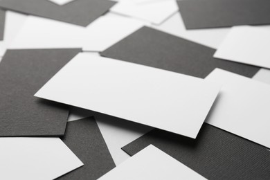 Photo of Blank black and white business cards on light background, closeup. Mockup for design