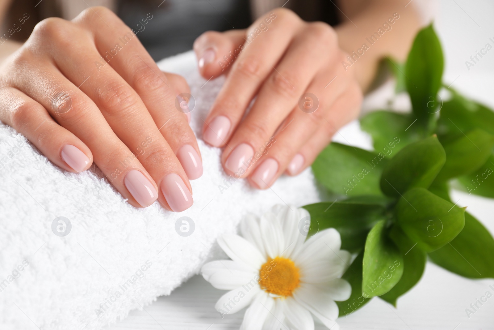 Photo of Closeup view of woman with beautiful hands at table. Spa treatment