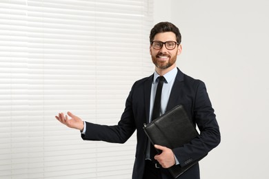 Handsome real estate agent with documents indoors