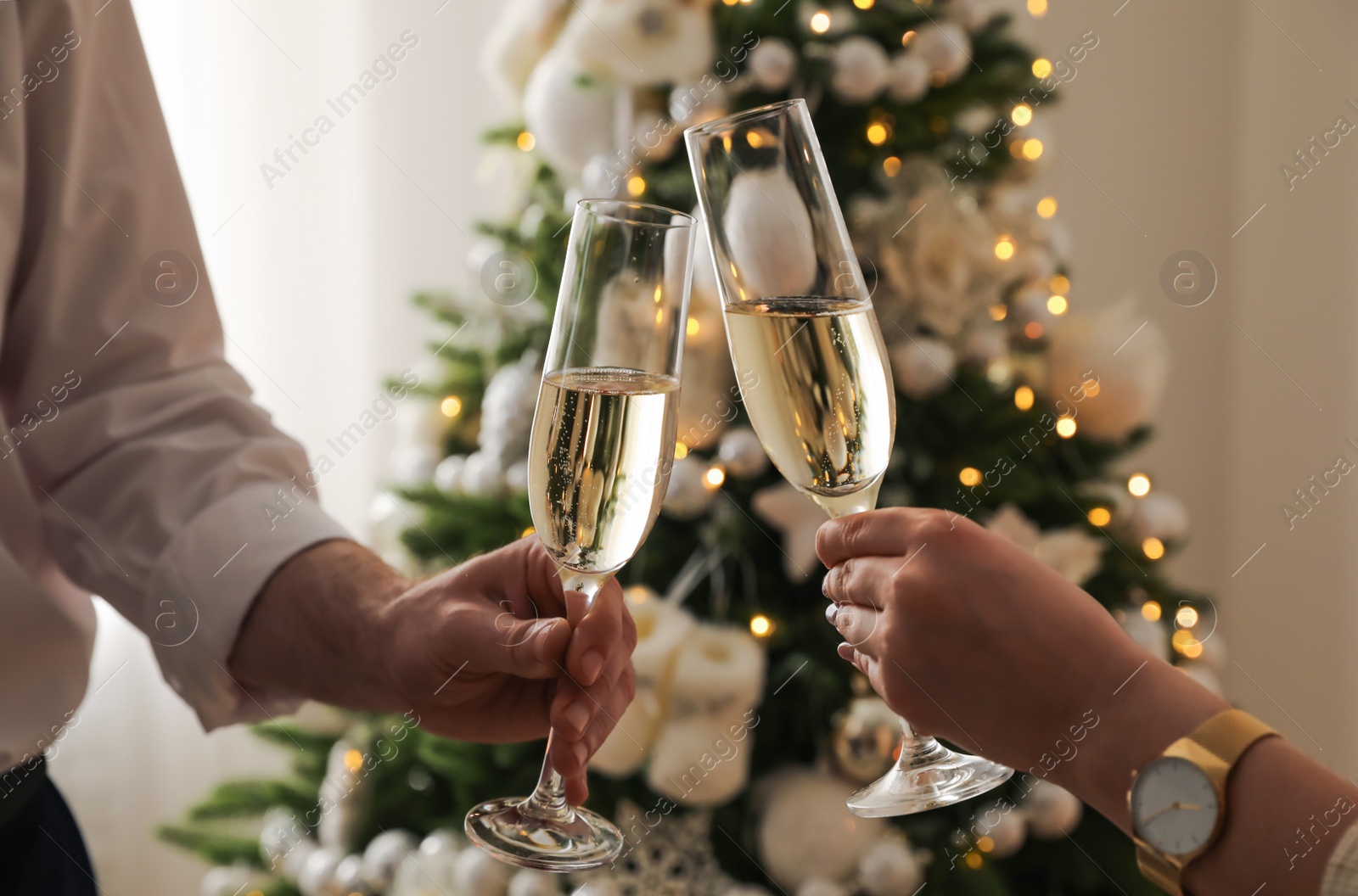 Photo of People clinking glasses with champagne at home, closeup