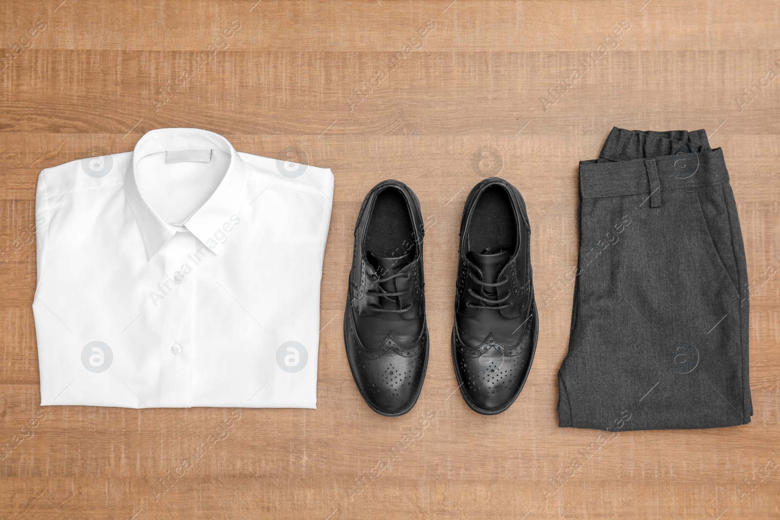 Photo of School uniform for boy on wooden background, top view