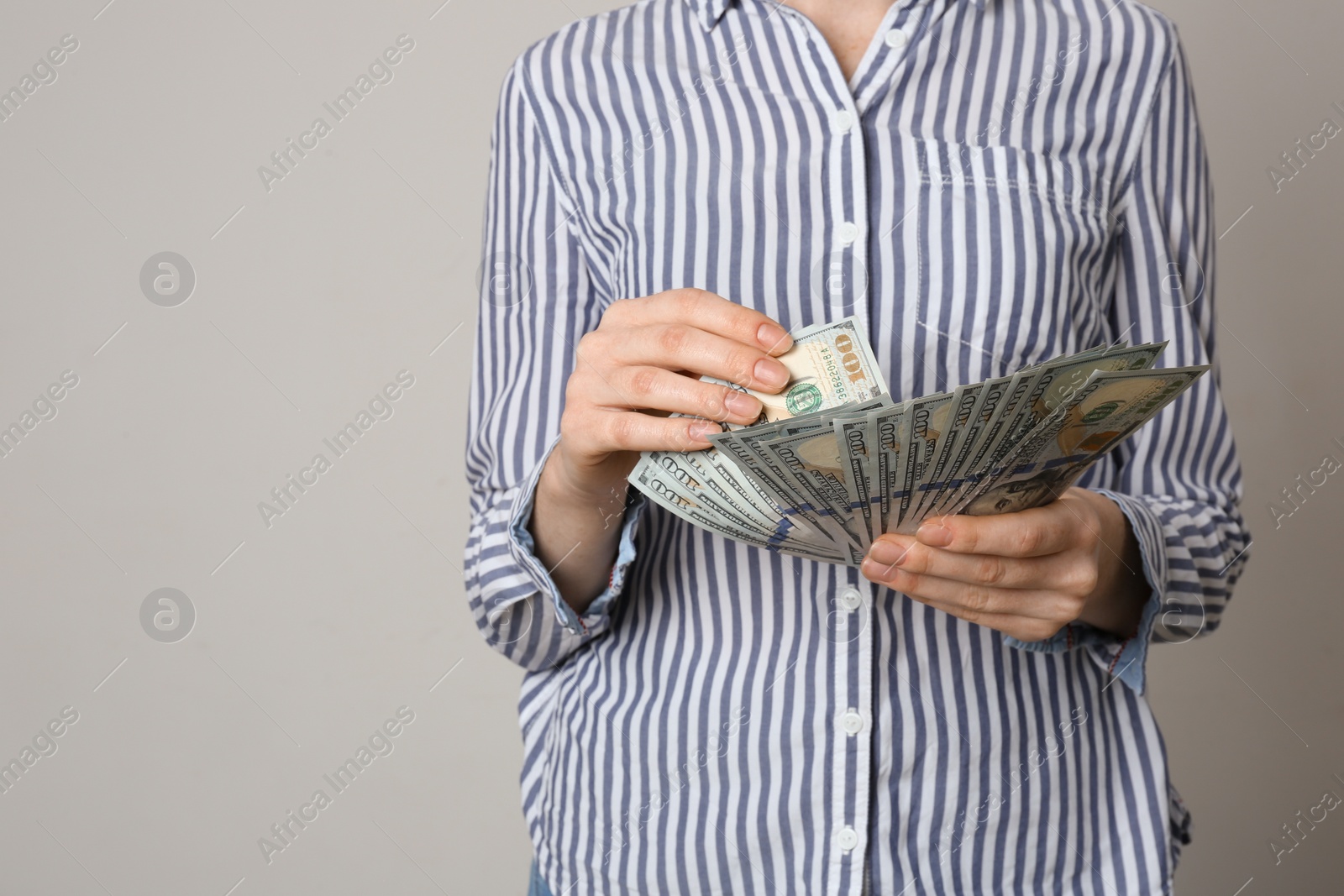 Photo of Woman with American money on grey background, closeup