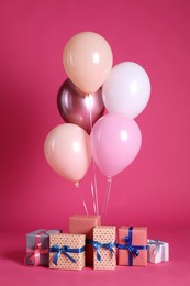 Many gift boxes and balloons near bright pink background