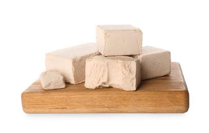 Photo of Wooden board with pieces of compressed yeast on white background