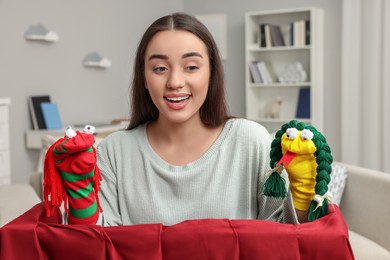 Happy woman performing puppet show at home