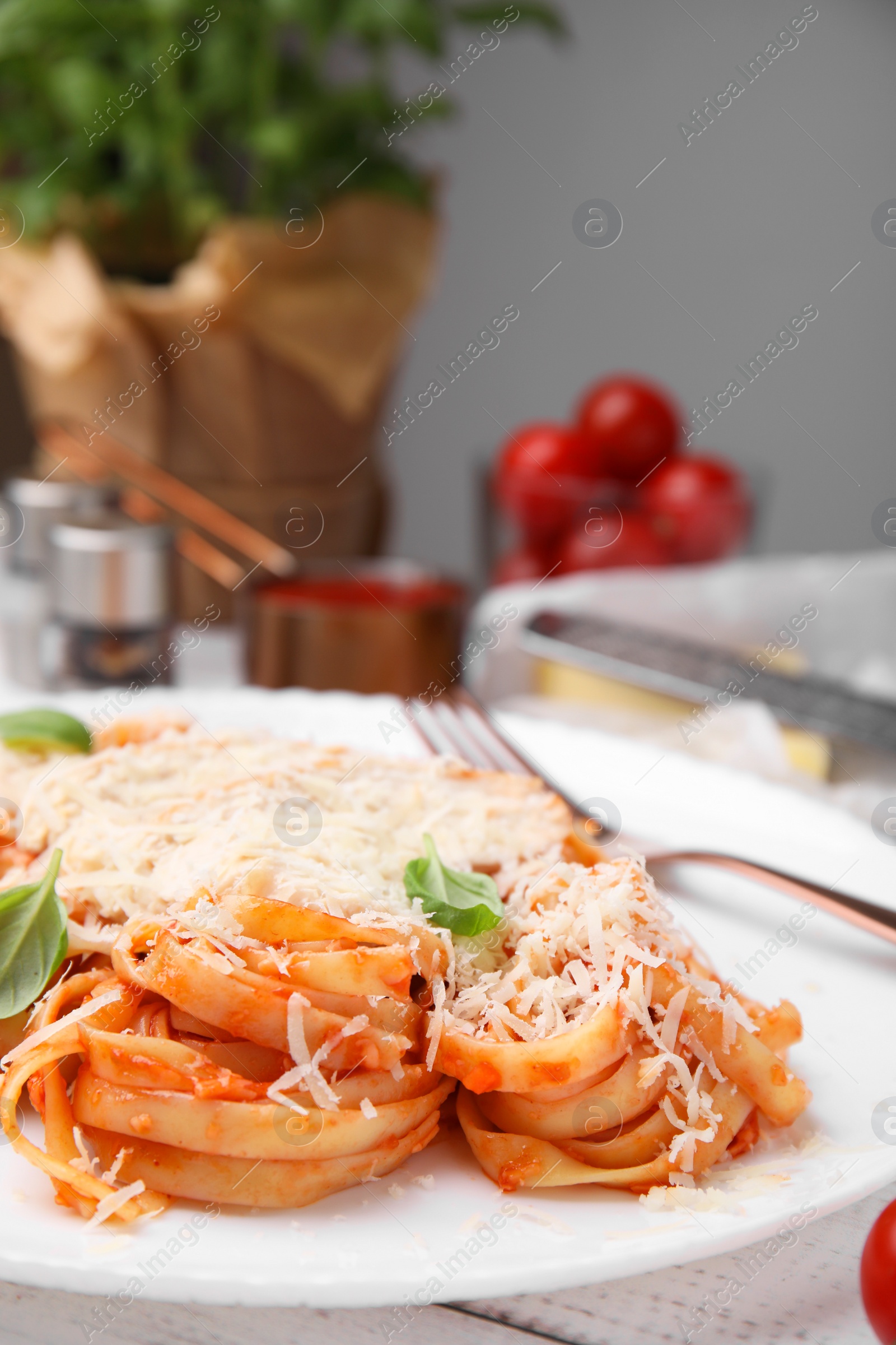 Photo of Delicious pasta with tomato sauce, chicken and parmesan cheese on white wooden table