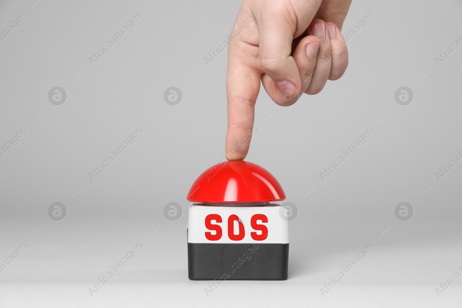 Image of Man pressing red SOS button at white background, closeup