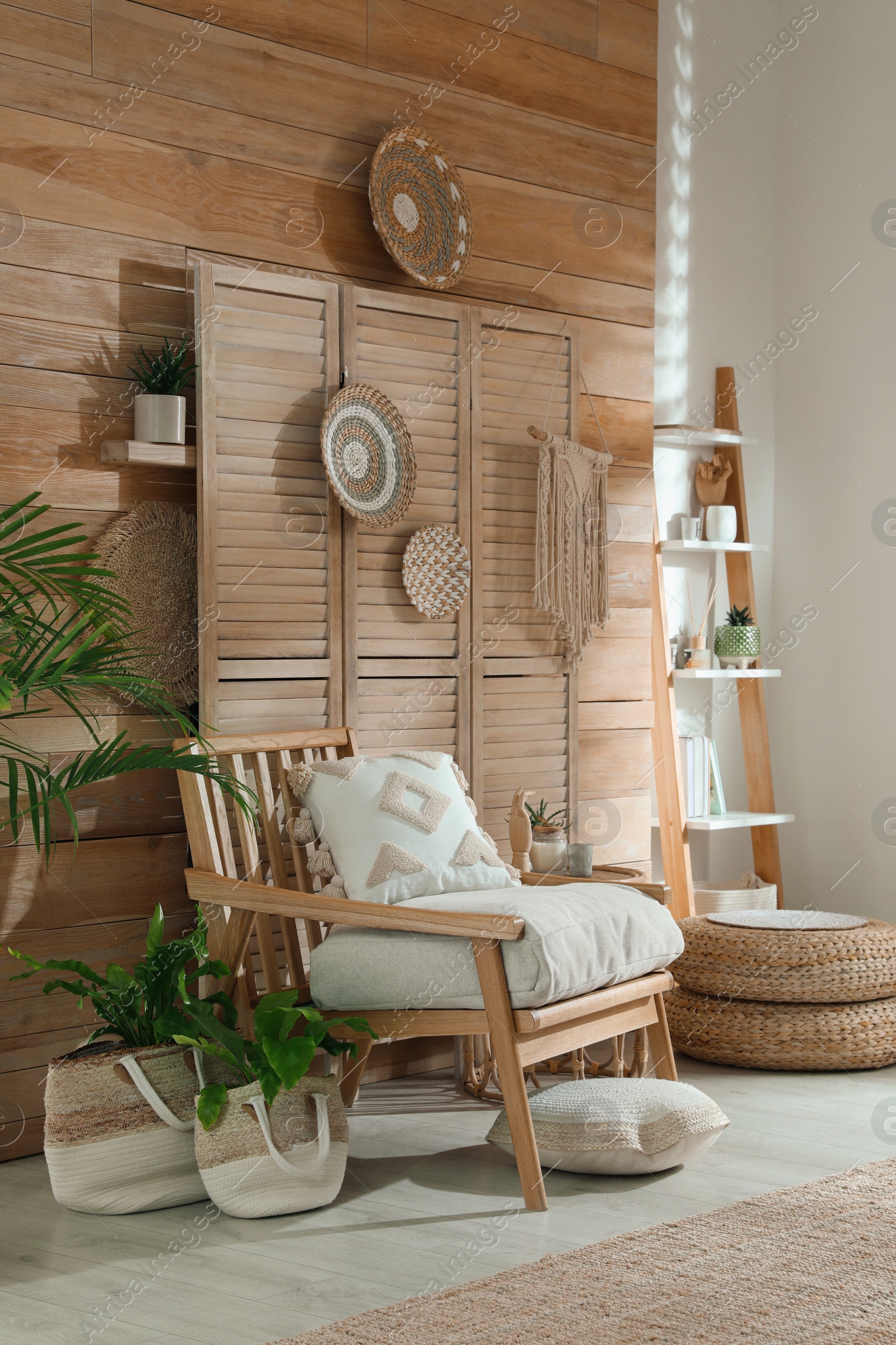 Photo of Stylish living room interior with comfortable wooden armchair and beautiful houseplants