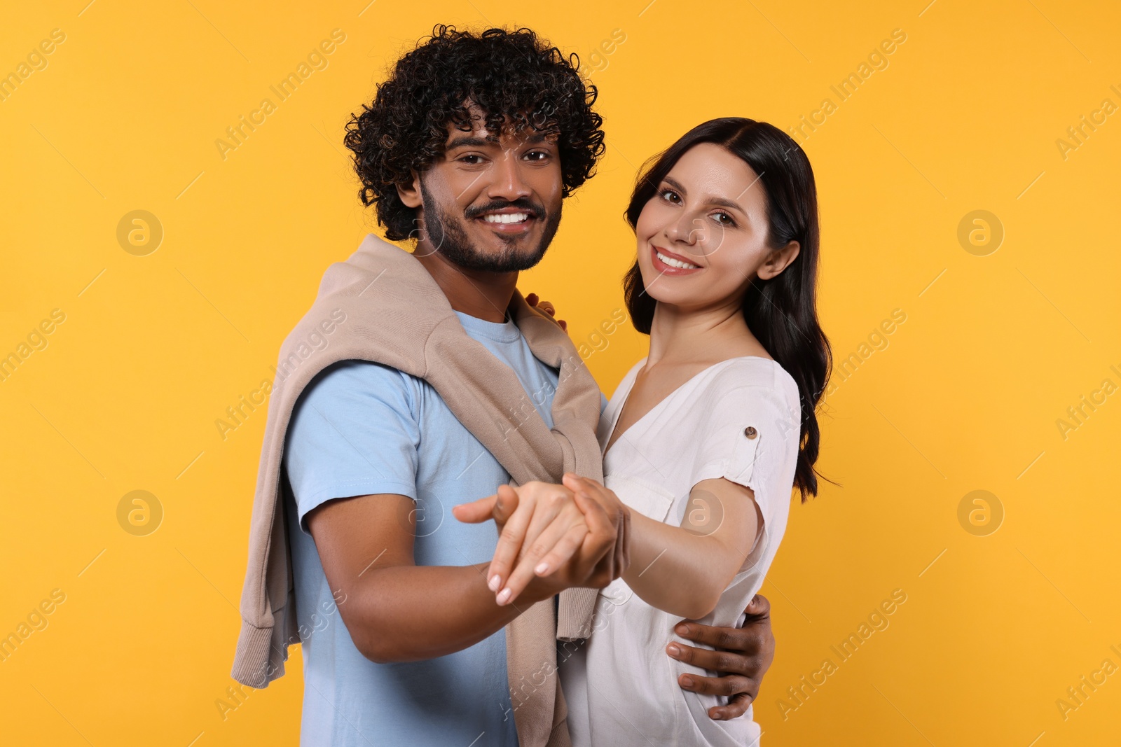 Photo of International dating. Happy couple dancing on yellow background