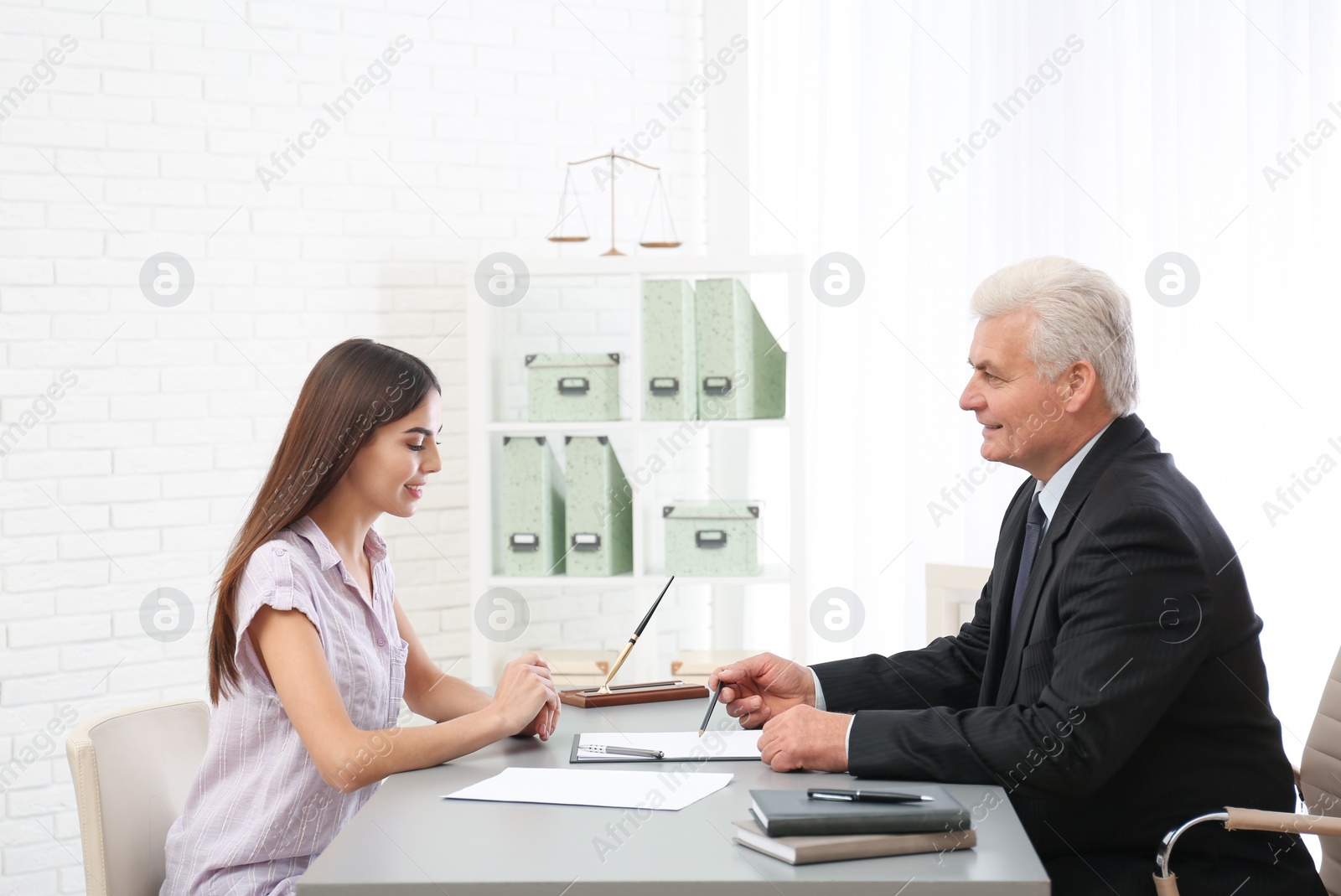 Photo of Young woman having meeting with lawyer in office