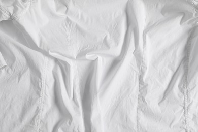 Photo of Crumpled white fabric as background, top view