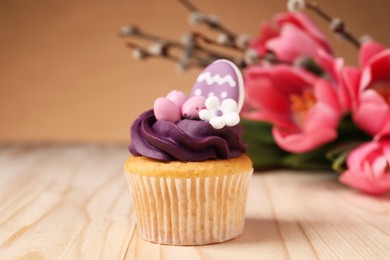 Photo of Tasty cupcake with Easter decor on wooden table