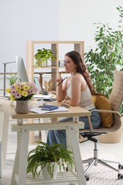 Young woman working at table in modern office