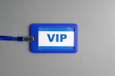 Photo of Vip badge on grey textured background, top view