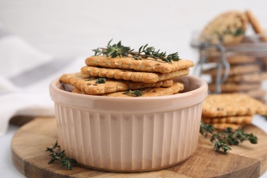 Cereal crackers with flax, sesame seeds and thyme in bowl on table, closeup