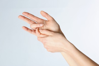 Photo of Woman with trigger finger condition on light background, closeup