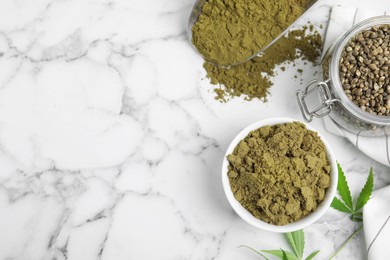 Hemp protein powder, seeds and fresh leaves on white marble table, flat lay. Space for text