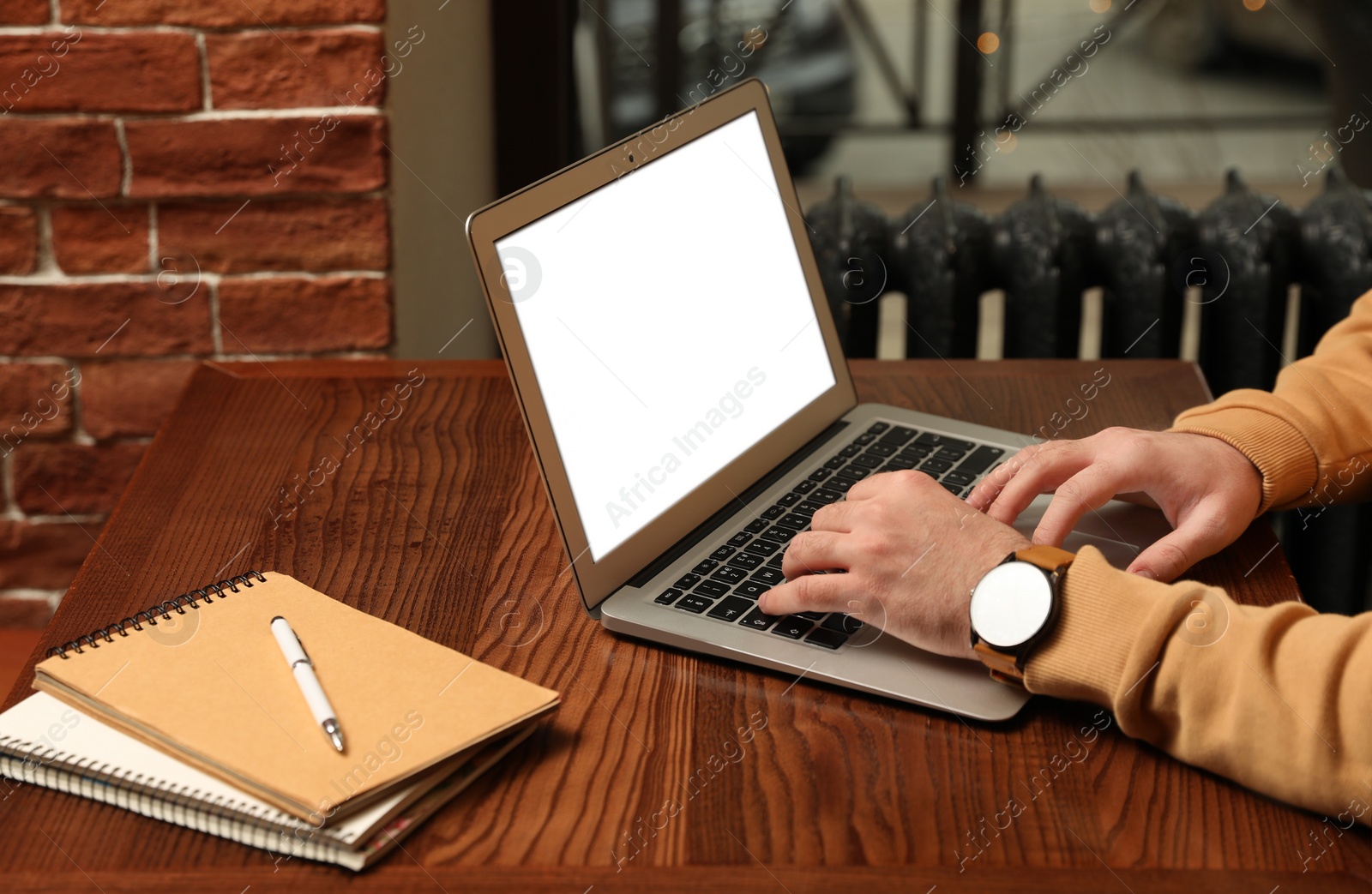 Photo of Male blogger working with laptop at table in cafe, closeup