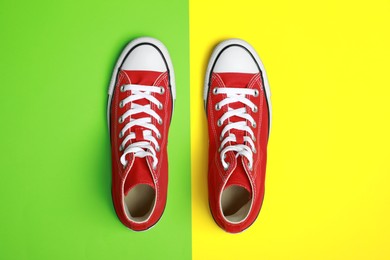 Photo of Pair of new stylish red sneakers on colorful background, flat lay