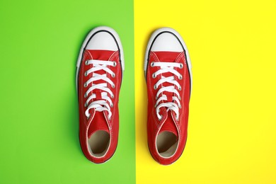 Pair of new stylish red sneakers on colorful background, flat lay