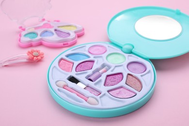 Photo of Decorative cosmetics for kids. Eye shadow palettes on pink background, closeup