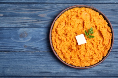 Photo of Plate with mashed sweet potatoes on wooden background, top view. Space for text