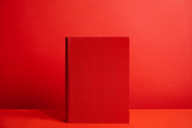 Photo of Hardcover book on red background. Space for design