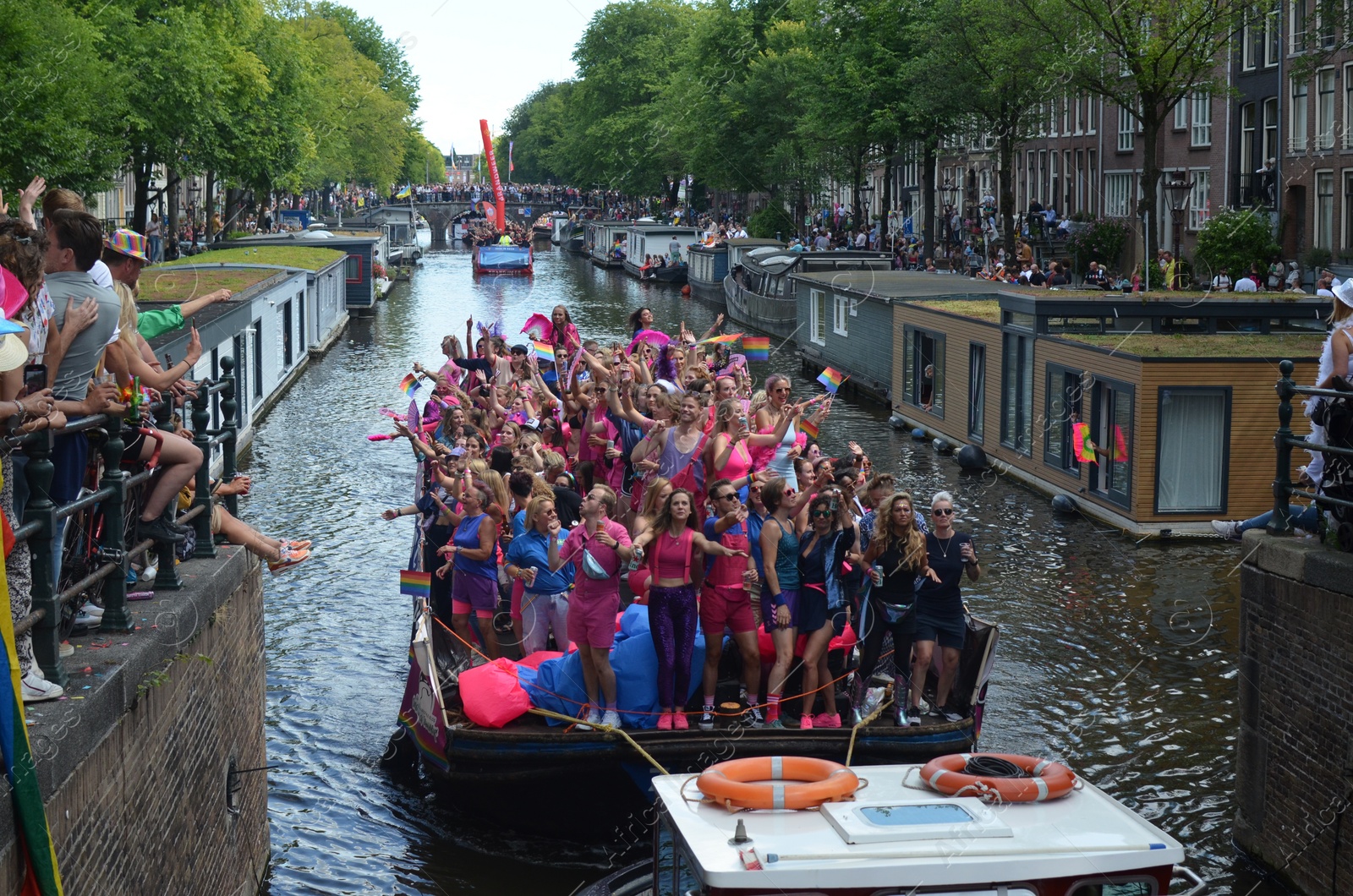 Photo of AMSTERDAM, NETHERLANDS - AUGUST 06, 2022: Many people in boats at LGBT pride parade on river