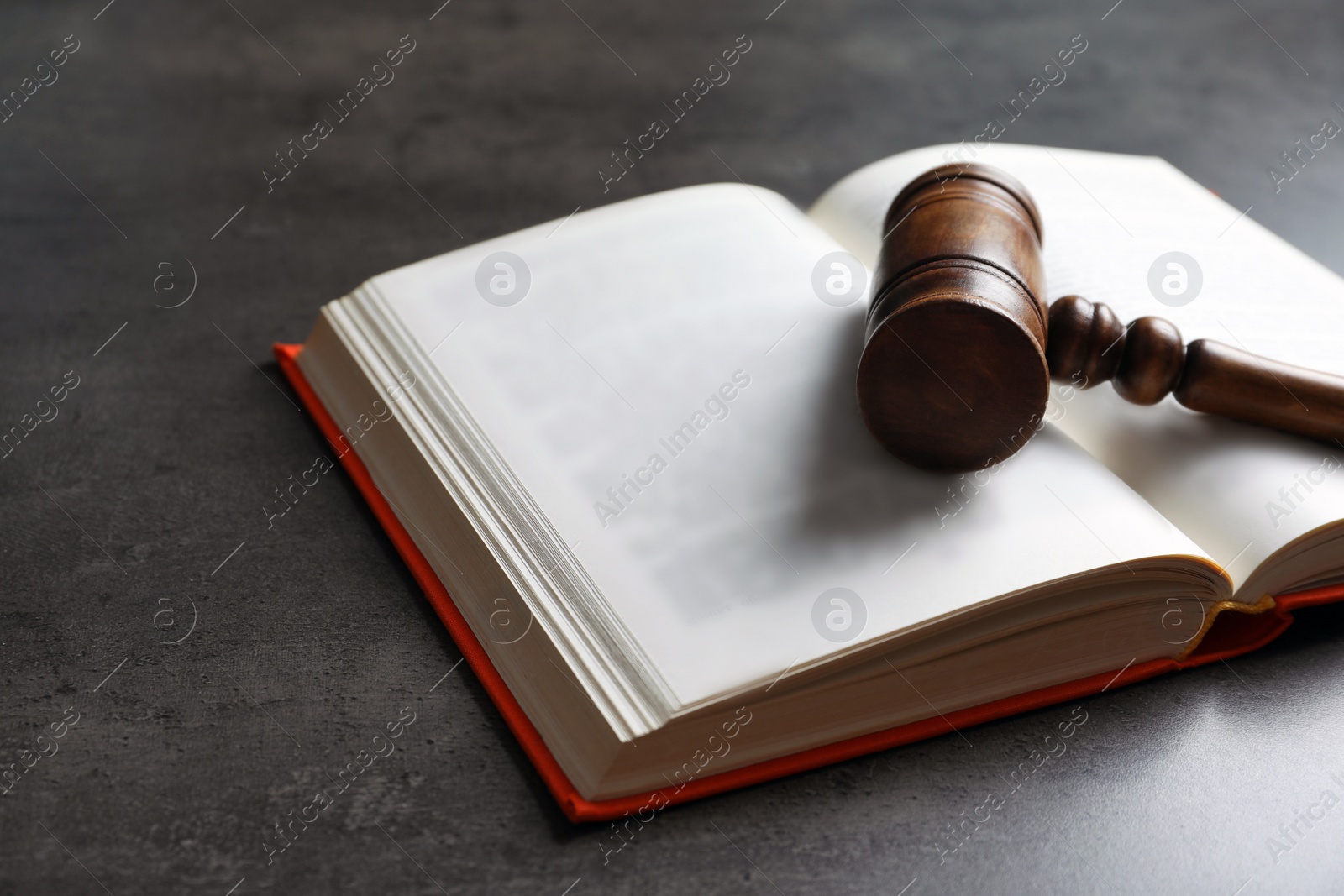 Photo of Wooden gavel and book on dark background. Law concept