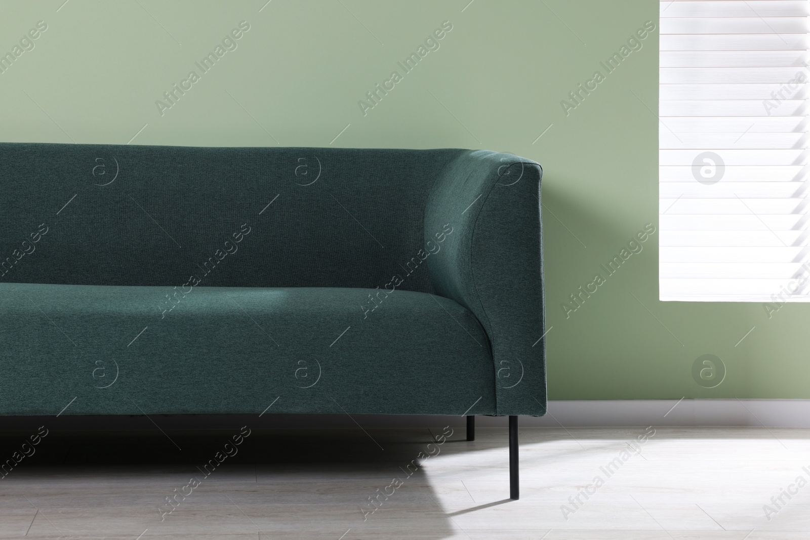 Photo of Comfortable sofa near light green wall indoors