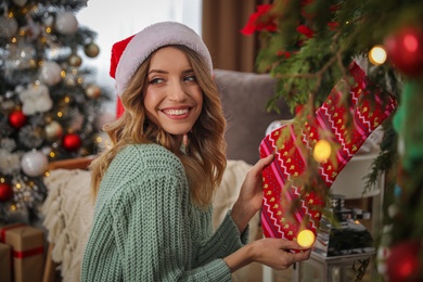 Young woman with Christmas stocking at home