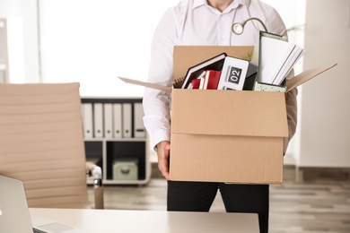 Young man with box of stuff in office, closeup