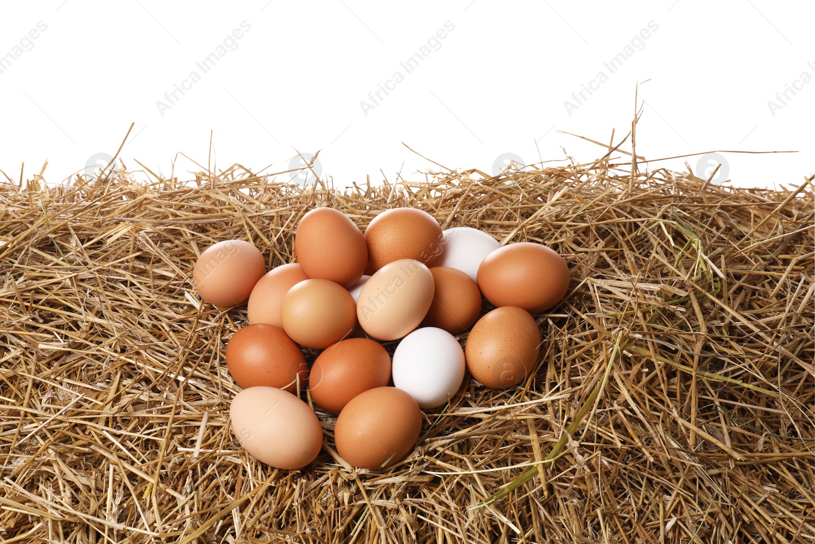 Photo of Fresh chicken eggs on dried straw against white background