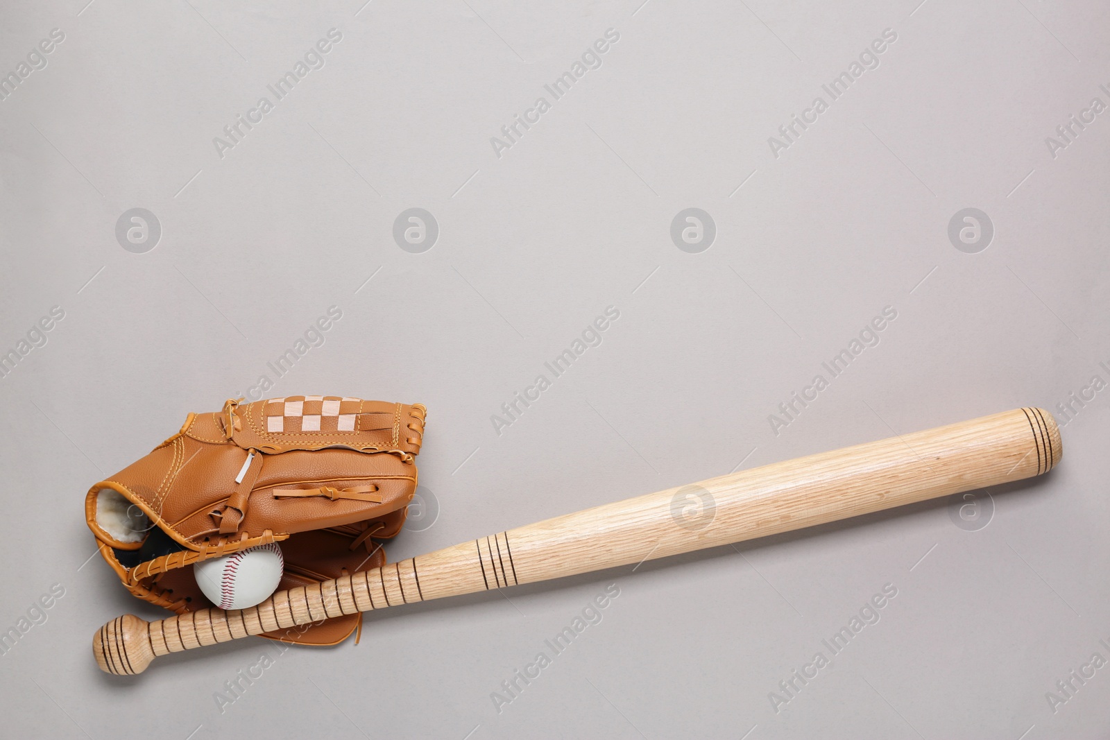 Photo of Baseball glove, bat and ball on light grey background, flat lay. Space for text