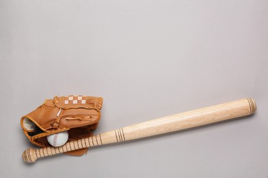 Photo of Baseball glove, bat and ball on light grey background, flat lay. Space for text