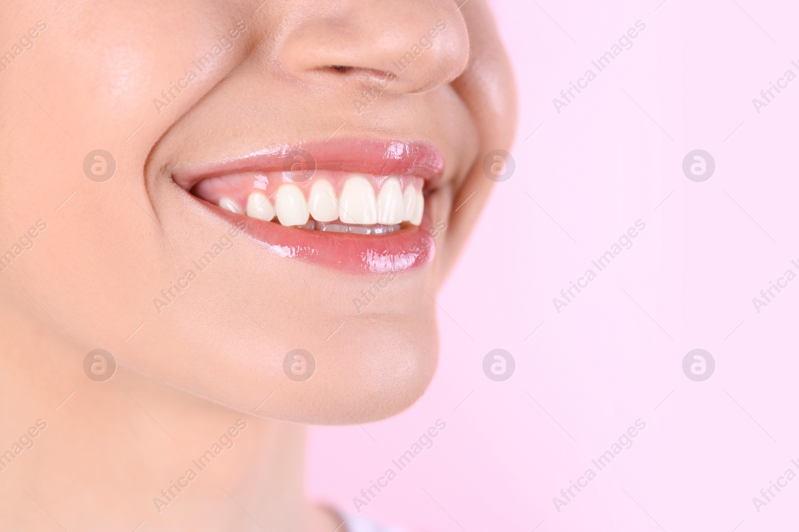 Photo of Young woman with healthy teeth and beautiful smile on color background, closeup. Space for text