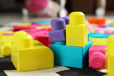 Photo of Colorful plastic building blocks on carpet indoors, closeup