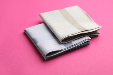 Photo of New handkerchiefs on pink background. Stylish accessory