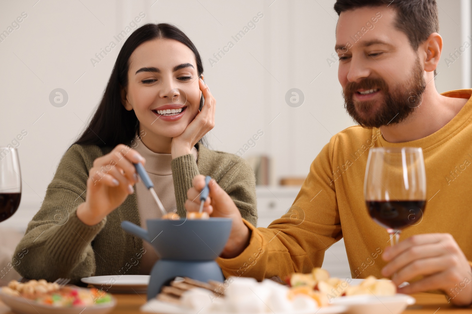 Photo of Affectionate couple enjoying fondue during romantic date at home